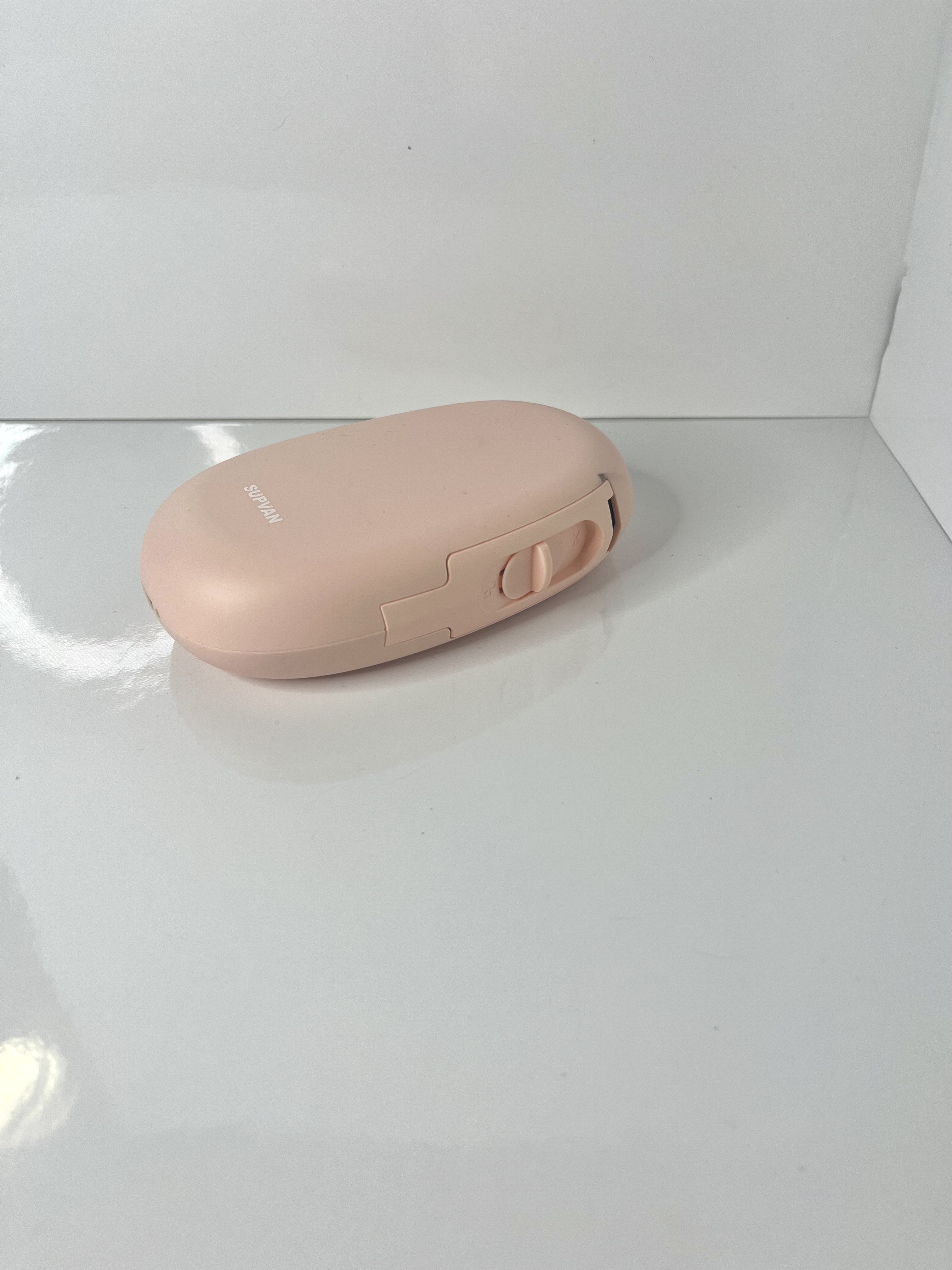 The same sticker printer is rotated to reveal the slot opening on its side and subtle design details.