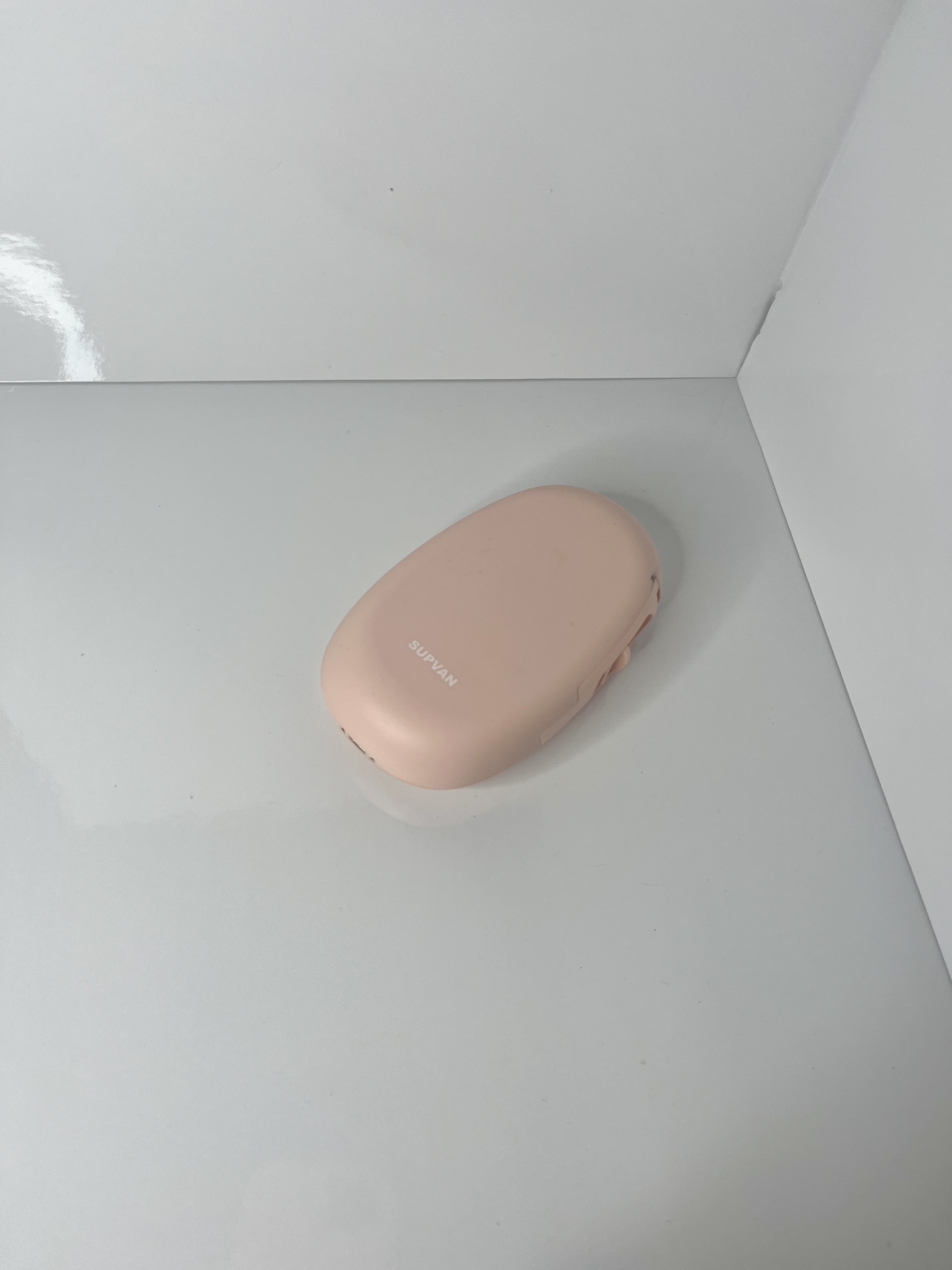 Another angled shot of the same printer highlights its compact, rounded design against the glossy white surface.