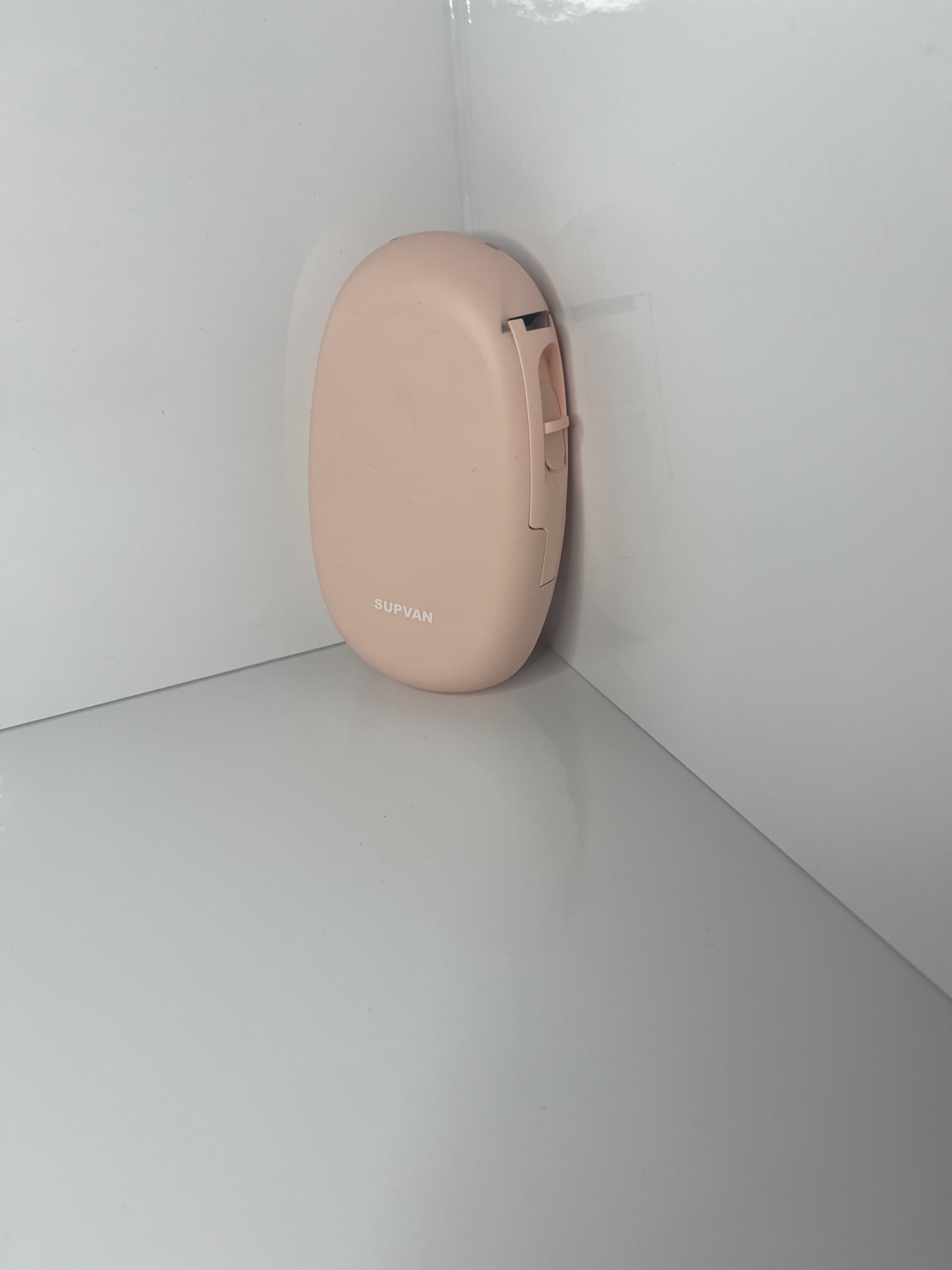 The printer is placed upright against the wall, revealing the slot opening along its side edge.